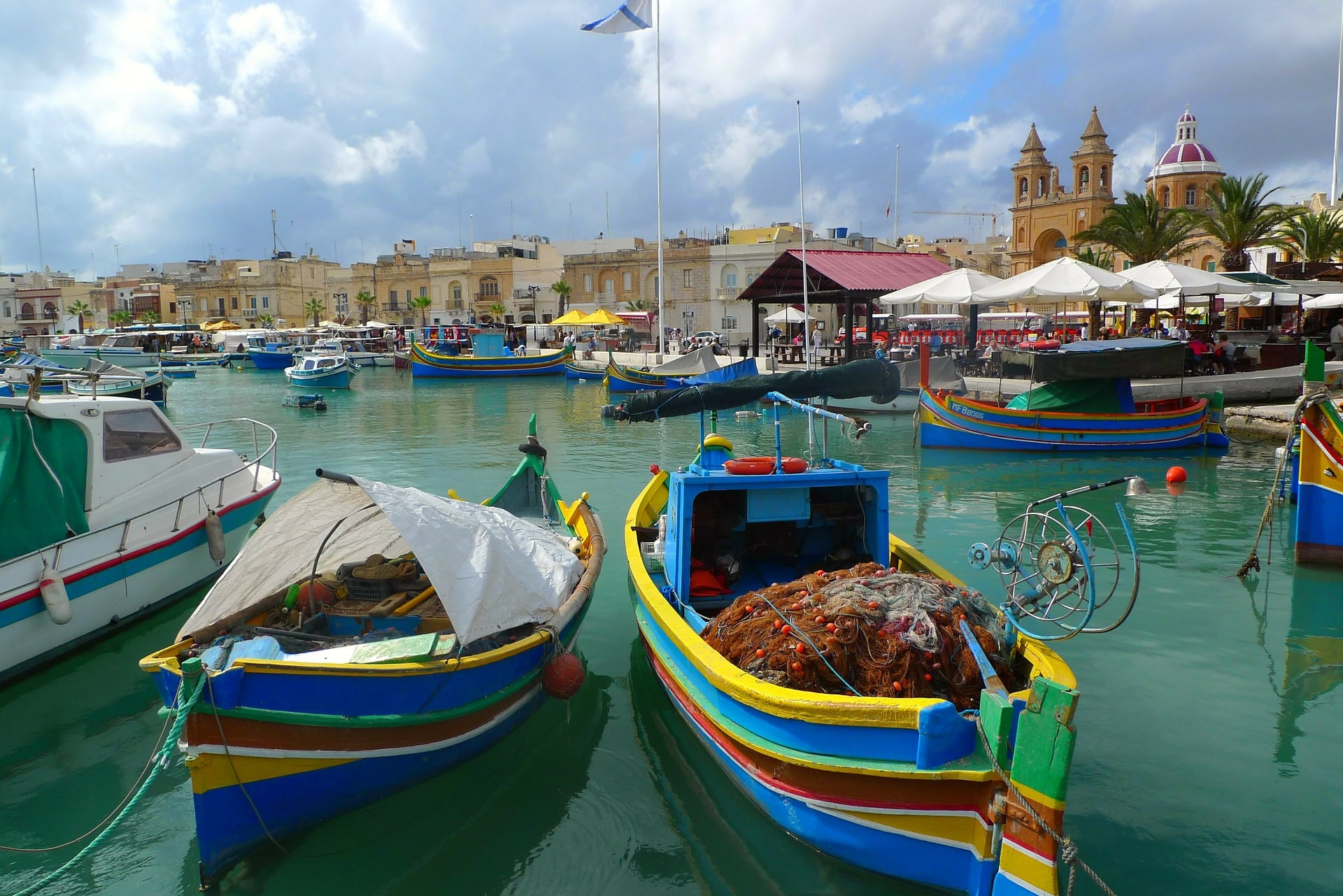 Widok na port rybacki z dużą ilością kolorowych łodzi w Marsaxlokk