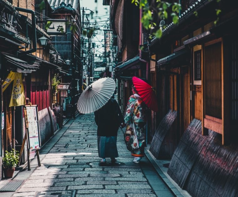 Kobieta i mężczyzna ubrani w kimona, przechadzający się uliczkami z tradycyjnymi domami samurajów w Kioto